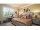 A luxurious main bedroom is showcased with stylish furniture, decorative accents, and large windows for natural light at 20186 Benissimo Dr, Venice, FL 34293