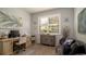 Inviting office featuring a wooden desk, comfortable seating, natural light, and pleasant coastal decor at 20186 Benissimo Dr, Venice, FL 34293