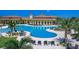 A luxurious community pool with lounge chairs and umbrellas surrounded by palm trees at 20186 Benissimo Dr, Venice, FL 34293
