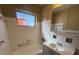 Bathroom with white tile, a tub, a sink with cabinet and a mirrored cabinet at 22332 Midway Blvd, Port Charlotte, FL 33952
