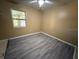 Bedroom with gray laminate flooring, a ceiling fan, and a sunlit window at 22332 Midway Blvd, Port Charlotte, FL 33952