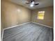 Bedroom with gray laminate flooring, a ceiling fan, and a sunlit window at 22332 Midway Blvd, Port Charlotte, FL 33952