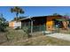 A well-maintained single-story home with screened-in porch and green fencing offers privacy at 22332 Midway Blvd, Port Charlotte, FL 33952