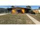 Charming single-story home featuring a bright yellow exterior, well-kept lawn, and inviting walkway to the entrance at 22332 Midway Blvd, Port Charlotte, FL 33952