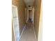 Long hallway features carpeting, neutral paint and custom built-in shelves at 22332 Midway Blvd, Port Charlotte, FL 33952