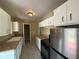 Bright kitchen features white cabinets, stainless steel appliances, and a view into a pantry for storage at 22332 Midway Blvd, Port Charlotte, FL 33952