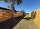 Side yard of the home featuring a well-maintained lawn and privacy fencing at 22332 Midway Blvd, Port Charlotte, FL 33952