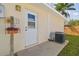 A backyard door is surrounded by greenery and an AC unit, providing easy access and functional design at 2412 15Th W St, Palmetto, FL 34221