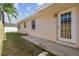 Exterior view of the home showing the backyard with a walkway leading to a door and a well-kept lawn at 2412 15Th W St, Palmetto, FL 34221