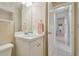 Well-lit bathroom with a white vanity, mirror, and doorway leading to a tiled hallway at 2412 15Th W St, Palmetto, FL 34221