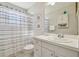All-white bathroom featuring a vanity, commode, shower, and decorative seashell artwork at 2412 15Th W St, Palmetto, FL 34221