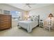 Comfortable bedroom with a ceiling fan, dresser, and bed by a sunny window at 2412 15Th W St, Palmetto, FL 34221
