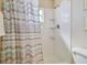 Tiled shower featuring built in shelving and stylish shower curtain at 2412 15Th W St, Palmetto, FL 34221