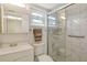All-white bathroom with a glass enclosed shower and marble-look tile at 3108 Lake Bayshore Dr # 211, Bradenton, FL 34205