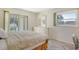 Bright bedroom with neutral tones, a dresser with a mirror, and a sliding door with water views at 3108 Lake Bayshore Dr # 211, Bradenton, FL 34205