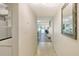 Neutral toned condo hallway with a view to an open concept living and dining room and an elegant mirror at 3108 Lake Bayshore Dr # 211, Bradenton, FL 34205