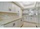 Updated kitchen featuring white cabinets, granite counters, and a decorative backsplash at 3108 Lake Bayshore Dr # 211, Bradenton, FL 34205