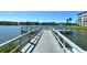 Waterfront condominium complex with a large pier, picnic seating, and beautiful water views on a sunny day at 3108 Lake Bayshore Dr # 211, Bradenton, FL 34205