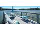 View of the seating area on a waterfront pier with table, chairs, and sunbathing lounge chairs at 3108 Lake Bayshore Dr # 211, Bradenton, FL 34205