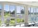 Views of the water and palm trees from a room with multiple large windows with an easy chair at 3108 Lake Bayshore Dr # 211, Bradenton, FL 34205