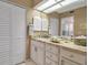 Well-lit bathroom featuring a granite countertop, storage cabinets, large mirror, and decorative accents at 318 108Th St W # 318, Bradenton, FL 34209