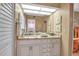 Bright bathroom featuring a granite countertop, storage cabinets, large mirror, and decorative accents at 318 108Th St W # 318, Bradenton, FL 34209