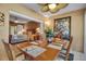 Cozy dining area with views into the main bedroom, featuring an elegant table set for six and a ceiling fan at 318 108Th St W # 318, Bradenton, FL 34209