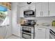 Modern kitchen featuring white cabinets, stainless appliances, and sleek countertops at 318 108Th St W # 318, Bradenton, FL 34209