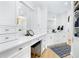 Elegant bathroom with white cabinetry, marble countertop, makeup vanity, and modern gold hardware at 340 Gulf Of Mexico Dr # 115, Longboat Key, FL 34228