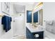 Modern bathroom featuring blue vanity with gold fixtures, decorative mirror and open walk-in shower at 340 Gulf Of Mexico Dr # 115, Longboat Key, FL 34228