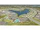 Aerial view showcasing a planned community's pool, playground, and tranquil lake with fountain at 427 157Th E Ct, Bradenton, FL 34212