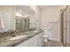 Bathroom featuring granite countertops, dual sinks, a walk-in shower, and decorative hardware at 427 157Th E Ct, Bradenton, FL 34212