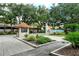 Community entrance featuring a guard house, mature trees, landscaping, and signage at 4423 Park Lake N Ter, Bradenton, FL 34209