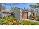 A one-car garage with brown door and vibrant landscaping offers curb appeal at 4423 Park Lake N Ter, Bradenton, FL 34209
