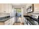 Updated kitchen with white cabinets, stainless appliances, black countertops, and patio access at 4423 Park Lake N Ter, Bradenton, FL 34209
