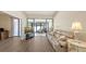 Living room with hardwood floors, comfortable sofa, and view to the Florida room with sliding glass doors at 4423 Park Lake N Ter, Bradenton, FL 34209