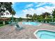 Community pool and lounge area, featuring seating and lush landscaping, on a sunny day at 4423 Park Lake N Ter, Bradenton, FL 34209