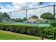 Exterior view of tennis courts with green fencing and hedges, and surrounding neighborhood buildings at 4423 Park Lake N Ter, Bradenton, FL 34209