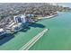 Aerial view of waterfront condos, pool and docks, with a boat wake visible in the green water at 4822 Ocean Blvd # 11E, Sarasota, FL 34242