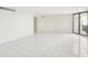 Bright empty living room with white tile flooring and glass sliding door to a balcony at 4822 Ocean Blvd # 11E, Sarasota, FL 34242