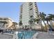 Upscale condo pool surrounded by seating and swaying palms at 4822 Ocean Blvd # 11E, Sarasota, FL 34242