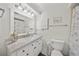 Bathroom features a white vanity with marble countertop and a shower with floral curtain at 511 68Th St, Holmes Beach, FL 34217