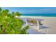 White sand beach featuring a wooden bench with beach plants in the foreground at 511 68Th St, Holmes Beach, FL 34217