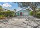 Charming coastal home featuring a well-manicured lawn, beautiful pavers, and a bright red front door at 511 68Th St, Holmes Beach, FL 34217