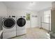 Laundry room featuring front load washer and dryer, tile flooring, and drying rack at 511 68Th St, Holmes Beach, FL 34217