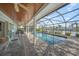 Screened-in pool and patio area with seating overlooking the canal at 511 68Th St, Holmes Beach, FL 34217