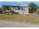 Charming single-story home with well-maintained lawn and mature palm trees, covered porch, and tidy landscaping at 5235 Cherry Hill Ave, Sarasota, FL 34234