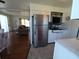 Bright kitchen with stainless steel refrigerator and white cabinets, seamlessly connecting to the inviting living area at 5235 Cherry Hill Ave, Sarasota, FL 34234