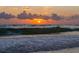 Beautiful beach sunset featuring waves rolling in under a cloudy sky with the sun's glow at 525 68Th St St, Holmes Beach, FL 34217