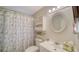 A clean bathroom featuring a shower, decorative mirror, and tropical-themed decor at 534 Sutton Pl, Longboat Key, FL 34228